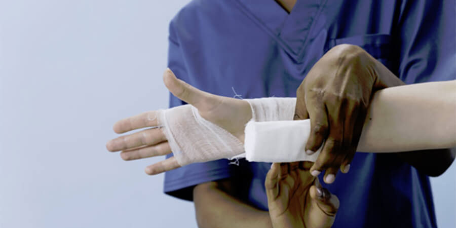 Doctor applying bandage to a sprained wrist.