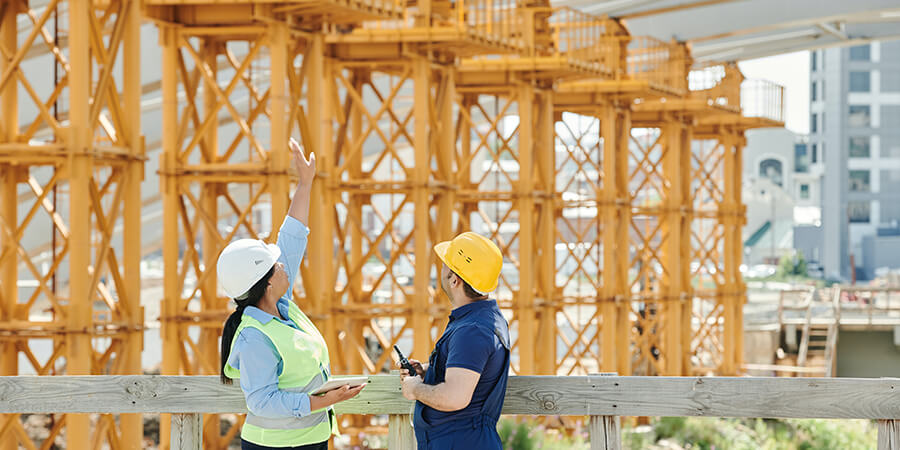 Two contractors working on a large bridge project.