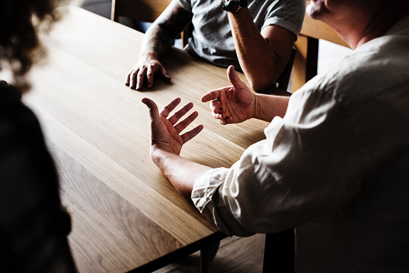 People sitting around a wooden table.