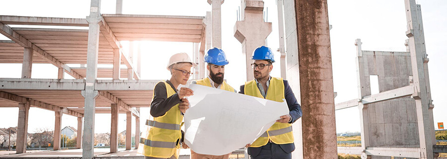 Construction managers on site looking at a drawing.