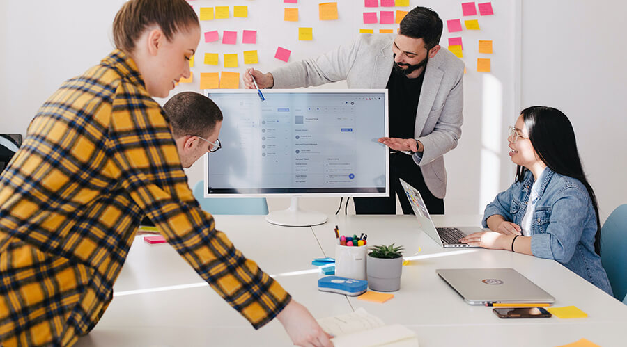 Group of people looking at data on a large monitor.