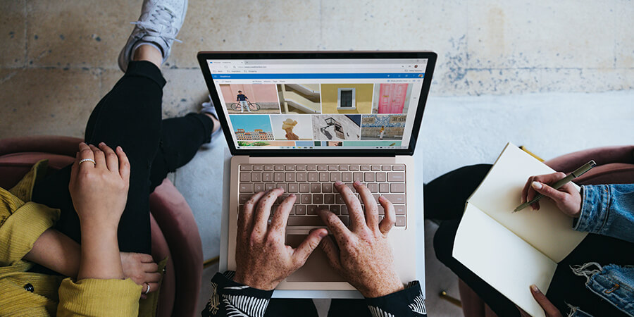 Group of three people using a laptop and taking notes.