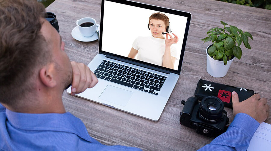 Person interacting with a customer service agent on a laptop.