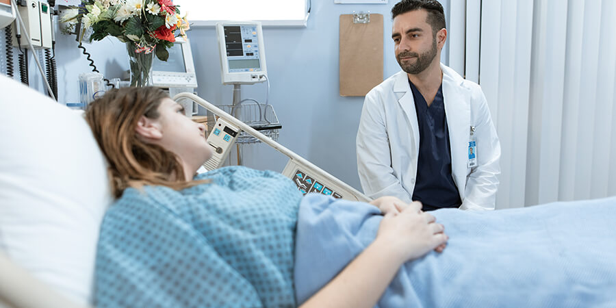 Doctor talking to a patient in a hospital bed.