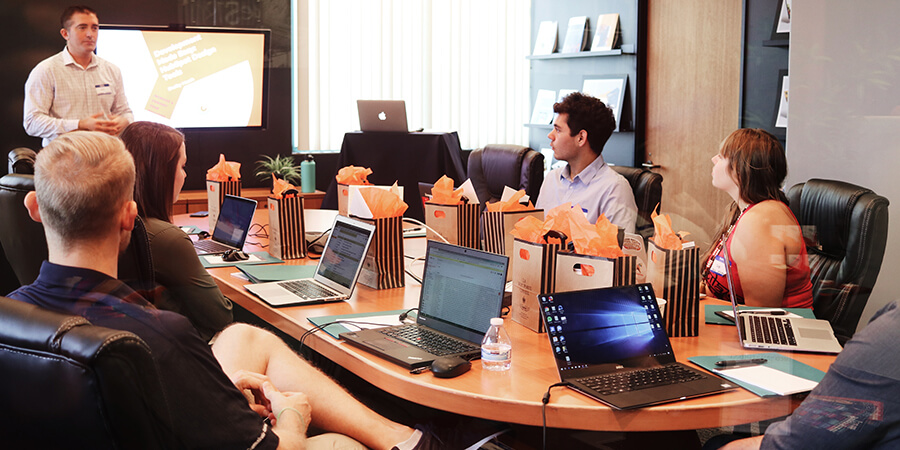 Effective business leader.  Group of people with laptops around a conference table.