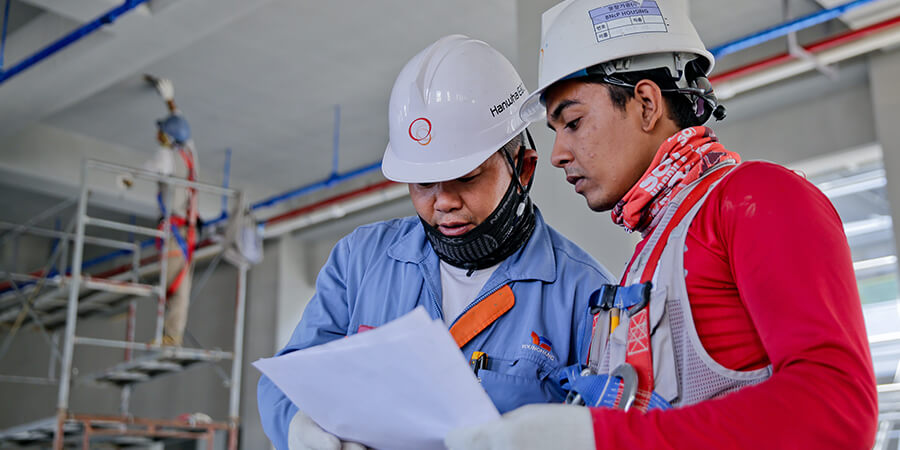 Two contractors looking at notes for a building project.