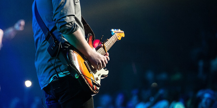 Playing guitar in front of an audience.