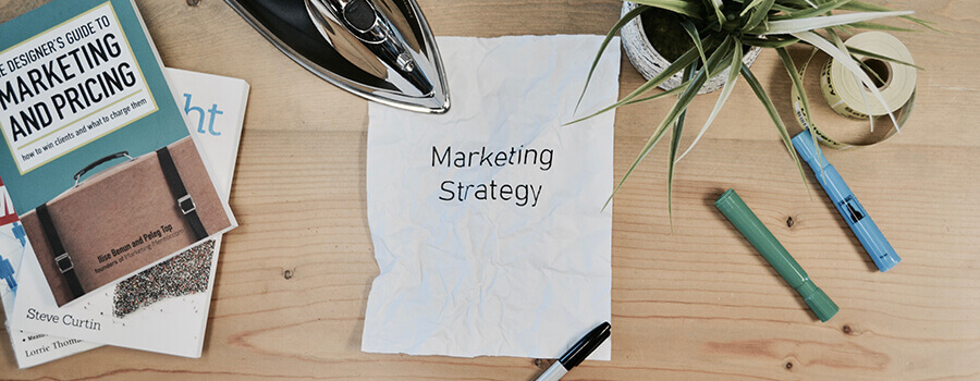 Table with books, pens and marketing strategy.