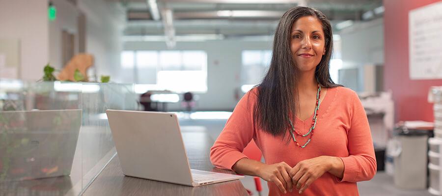 Smiling woman in a large open workspace.