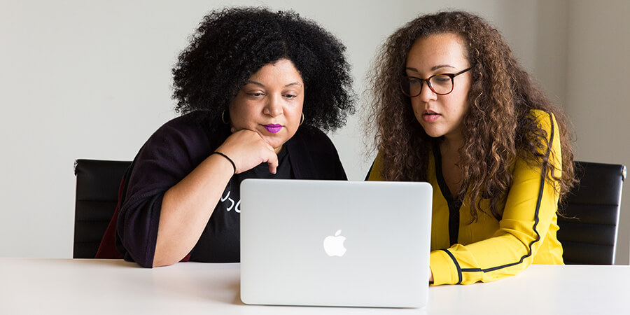 Two people looking at a laptop.