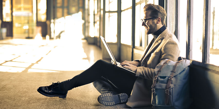 Man sitting on the ground using a laptop