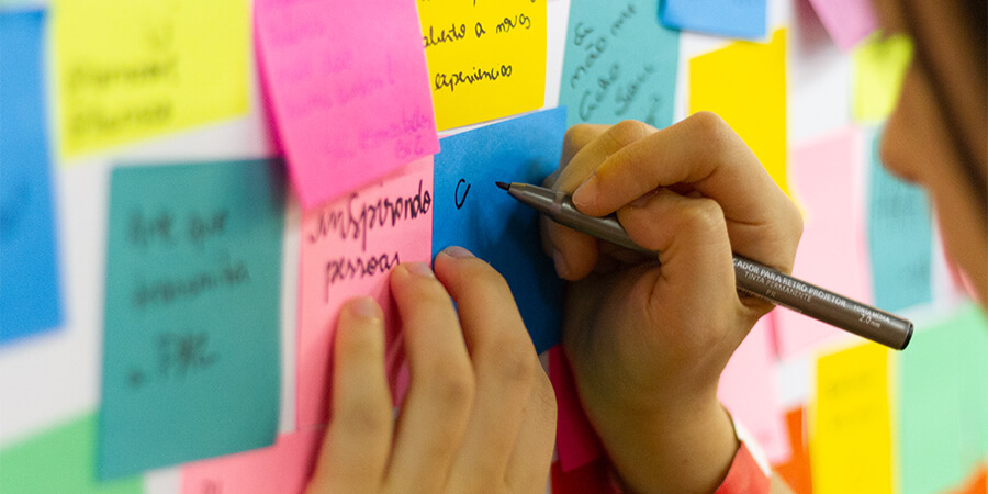 Person writing notes on Post-Its.