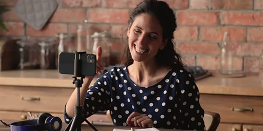 A woman practicing a speech in her kitchen.