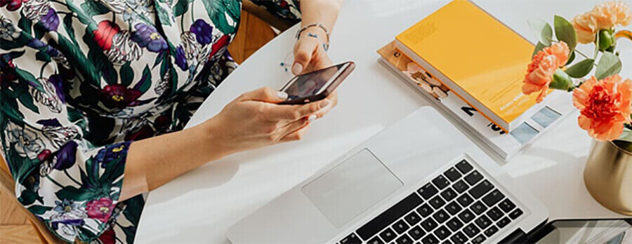 Remote worker using her phone and laptop.