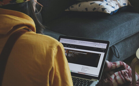 Looking over the shoulder of a remote worker using a laptop.