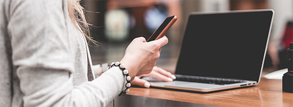 Remote worker using a phone and laptop.