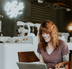 Smiling woman on laptop.