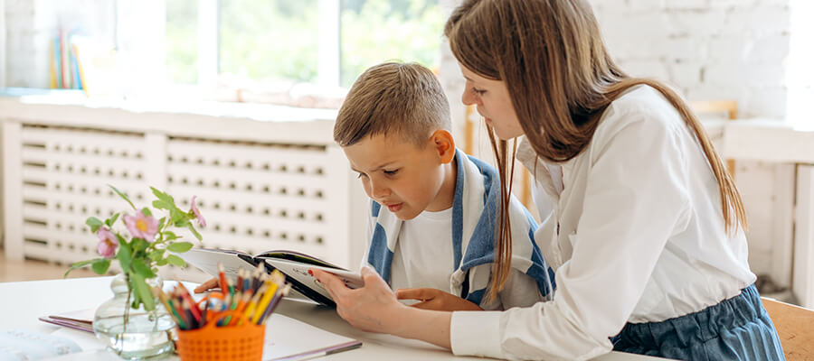 Teacher helping child with reading.