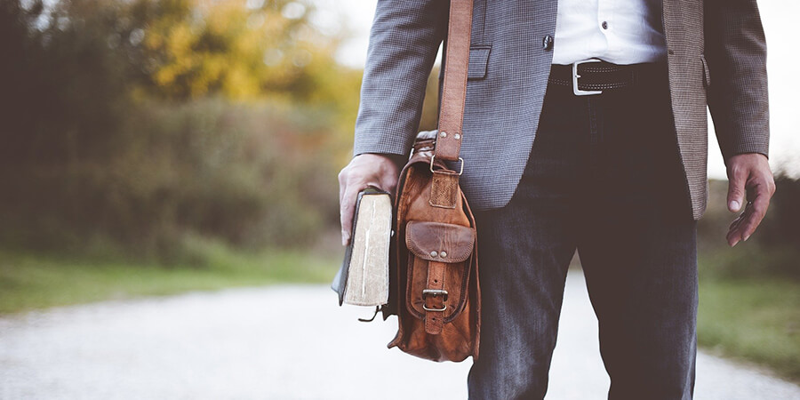 Teacher carrying a bag to school.