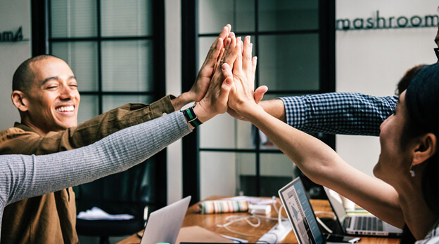 Team of young people high five.