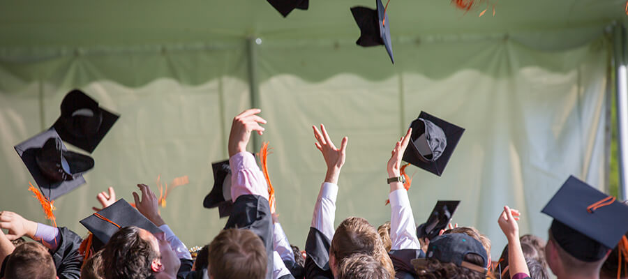 Graduates throwing their mortar board hats.