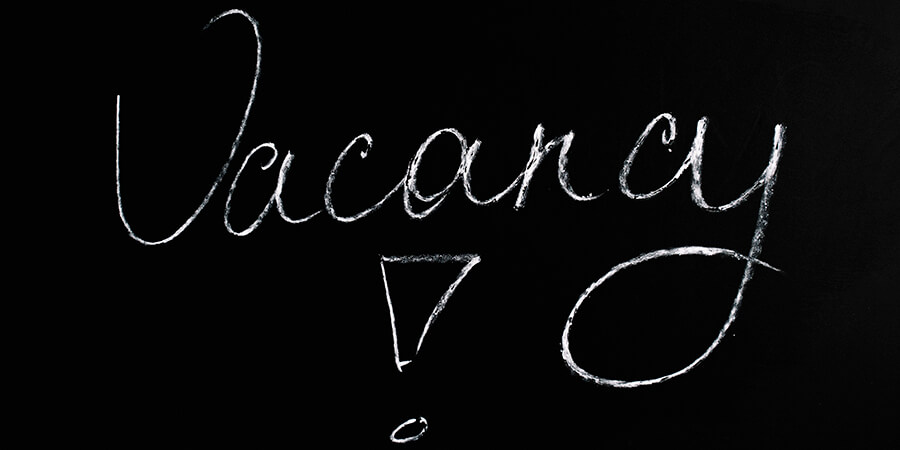 'Vacancy' written in chalk font on a black background.