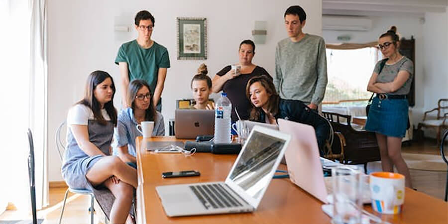 Group of people working around a laptop