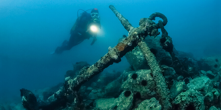 Wreck diver approaching old anchor.