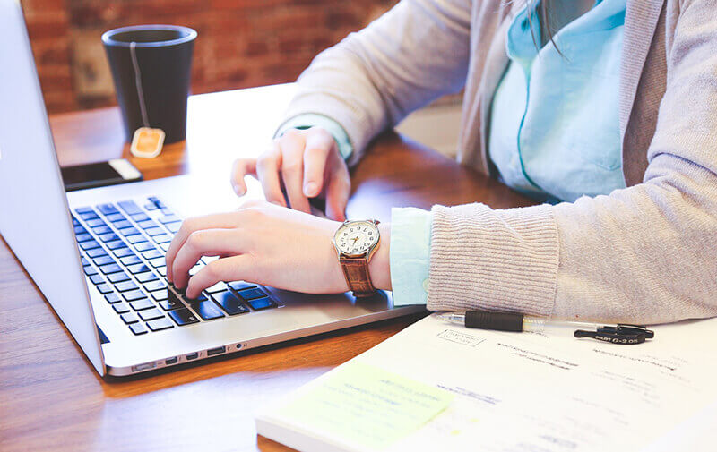 Young person writing on a laptop