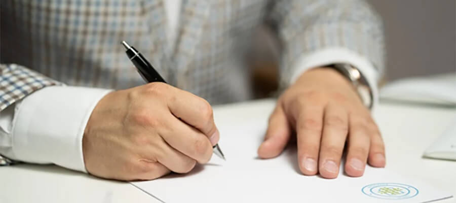 Person about to write on a piece of headed paper.